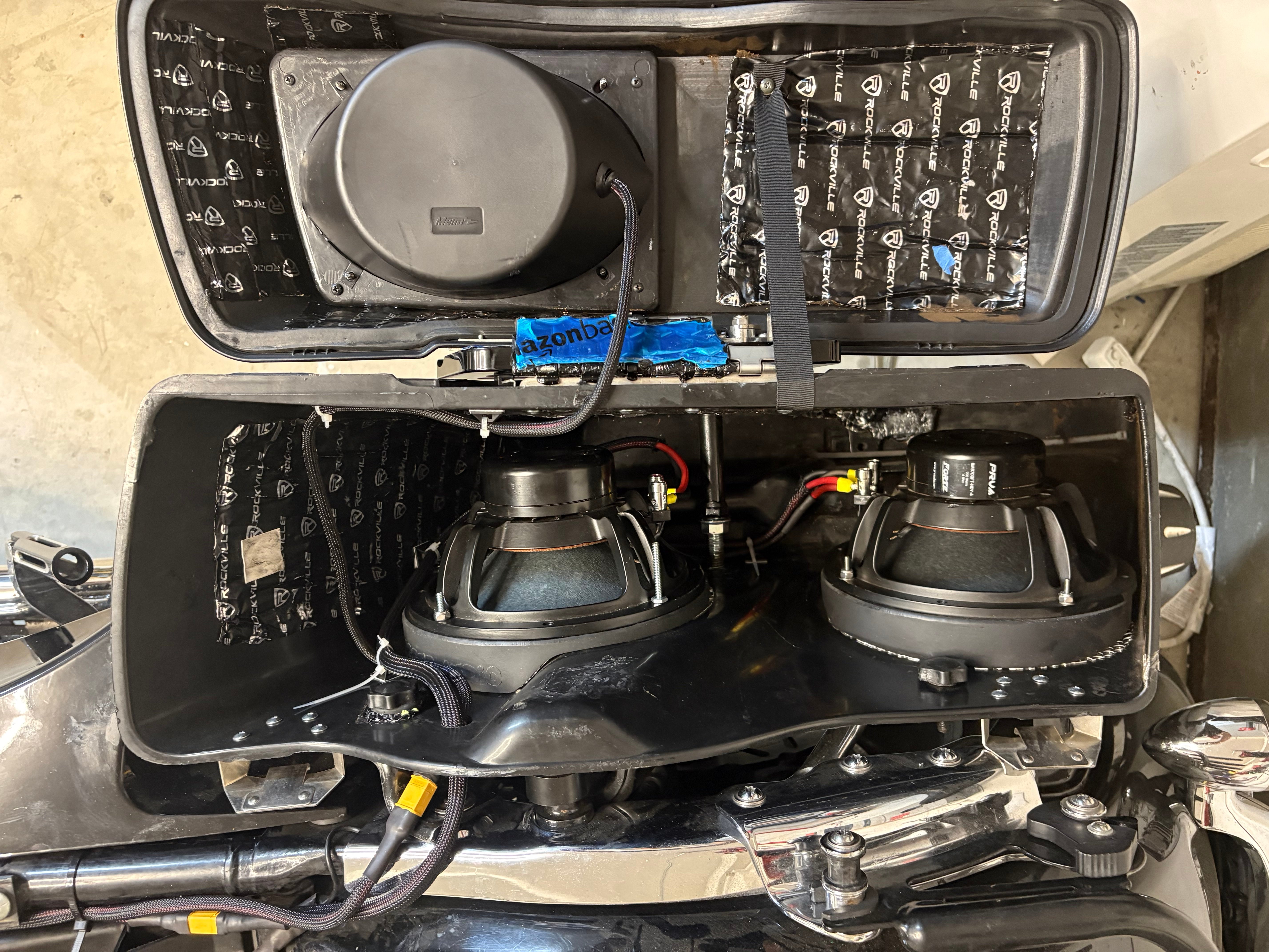 Dual saddlebag subwoofers with sound-deadened enclosures